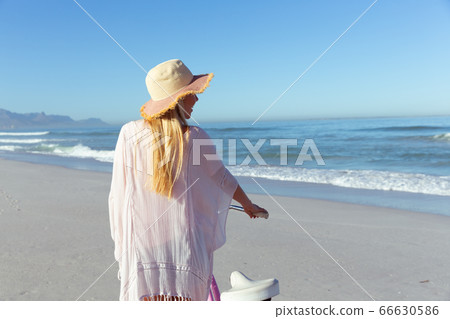 Caucasian woman spending time seaside and riding a bike Caucasian woman spending time seaside and riding a bike 66630586