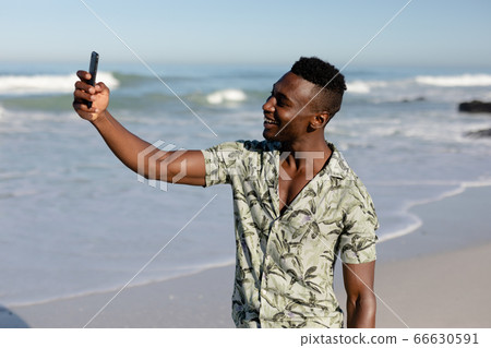 African american man taking a selfie on the beach African american man taking a selfie on the beach 66630591