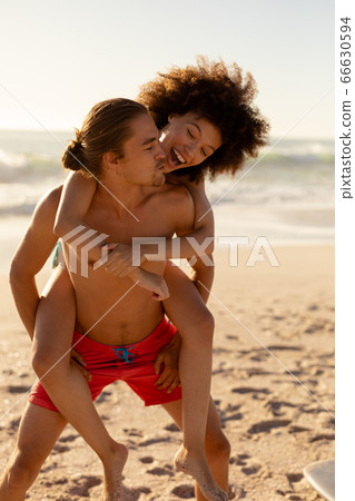 Multi-ethnic couple having fun on the beach 66630594