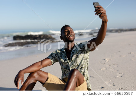 African american man taking a selfie on the beach African american man taking a selfie on the beach 66630597