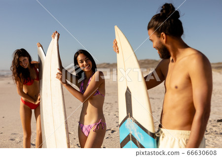 Multi-ethnic group of male and female, surfing on the beach Multi-ethnic group of male and female, surfing on the beach 66630608