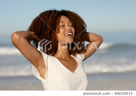 Mixed race woman enjoying her time on the beach Mixed race woman enjoying her time on the beach 66630615