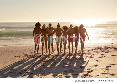 Multi-ethnic group of male and female standing on the beach Multi-ethnic group of male and female standing on the beach 66630620