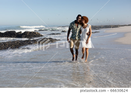 Happy couple spending time together on the beach Happy couple spending time together on the beach 66630624
