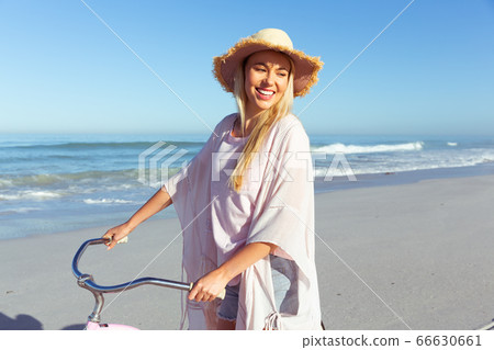 Caucasian woman spending time seaside and riding a bike Caucasian woman spending time seaside and riding a bike 66630661