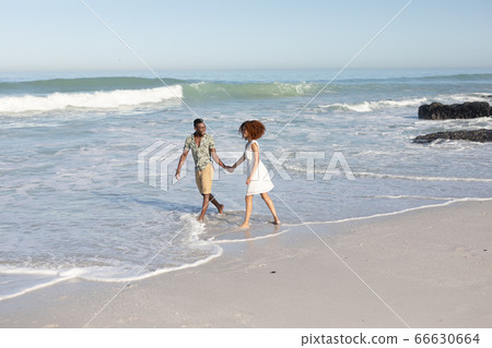 Happy couple spending time together on the beach Happy couple spending time together on the beach 66630664