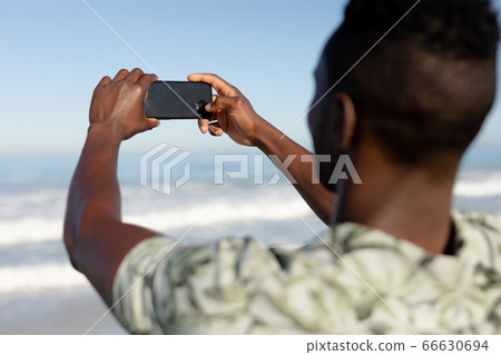 African american man taking a selfie on the beach 66630694