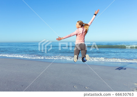 Caucasian woman spending time seaside wearing sportswear 66630763