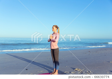 Caucasian woman practicing yoga seaside Caucasian woman practicing yoga seaside 66630774