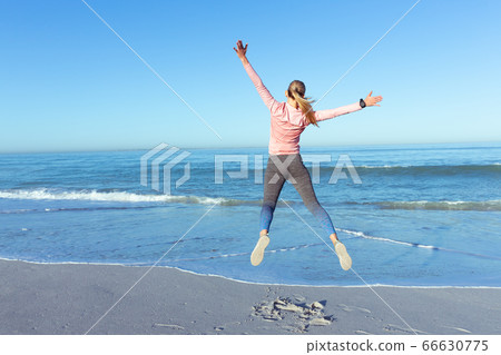 Caucasian woman spending time seaside wearing sportswear Caucasian woman spending time seaside wearing sportswear 66630775