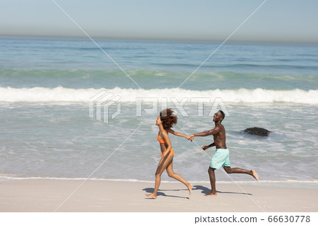 Happy couple spending time together on the beach Happy couple spending time together on the beach 66630778