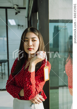 Beautiful young asian thai businesswoman in red shirt. Thoughtful Beautiful young asian thai businesswoman in red shirt. Thoughtful 66635991