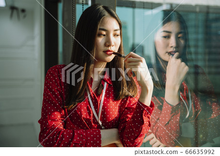 Beautiful young asian thai businesswoman in red shirt. Thoughtful Beautiful young asian thai businesswoman in red shirt. Thoughtful 66635992