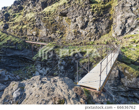 Landscape with wooden footbridge over a blue Landscape with wooden footbridge over a blue 66636762