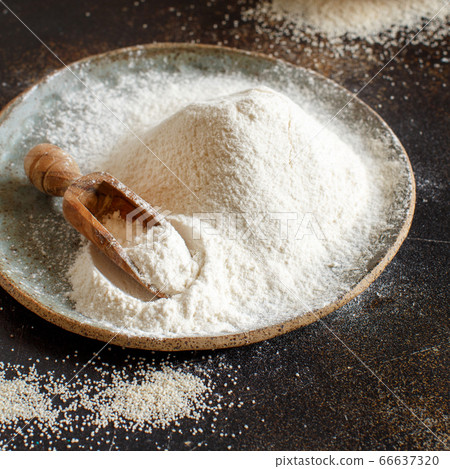 Raw fonio flour and seeds with a spoon on dark Raw fonio flour and seeds with a spoon on dark 66637320