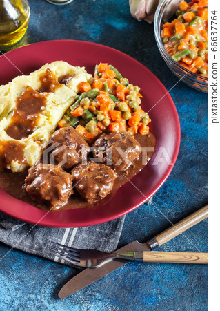 Roasted meatballs in dark sauce with mashed 66637764