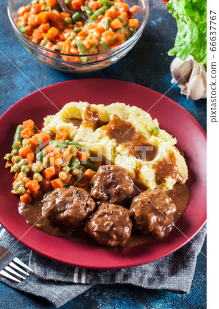 Roasted meatballs in dark sauce with mashed 66637767