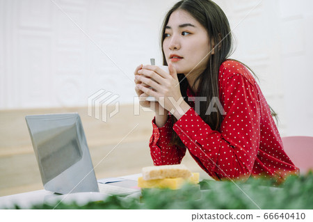 Woman working at home. Eating snack while working. 66640410