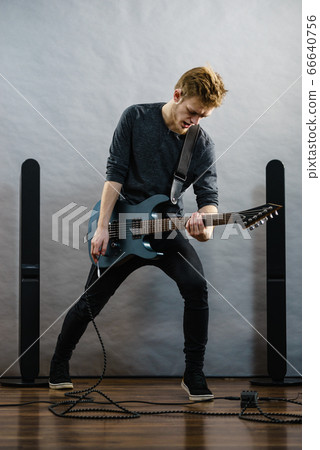 Young man playing electric guitar Young man playing electric guitar 66640756