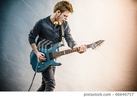 Young man playing electric guitar 66640757
