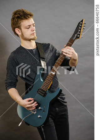 Young man playing electric guitar Young man playing electric guitar 66640758