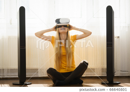 Girl wearing virtual reality goggles at home Girl wearing virtual reality goggles at home 66640801