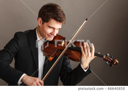 Man man dressed elegantly playing violin 66640850