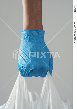 man wearing latex gloves carrying a shopping bag man wearing latex gloves carrying a shopping bag 66648209