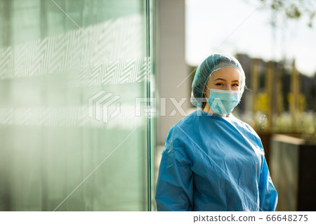 Female medical doctor or nurse in surgical mask and surgical cap looking at you Female medical doctor or nurse in surgical mask and surgical cap looking at you 66648275