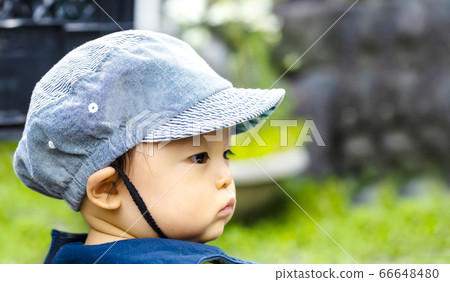 Side view of a child wearing a hat and green back Side view of a child wearing a hat and green back 66648480
