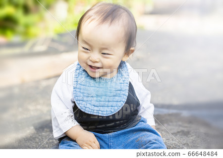 Overjoyed child touching the sand while playing with sand outside Overjoyed child touching the sand while playing with sand outside 66648484