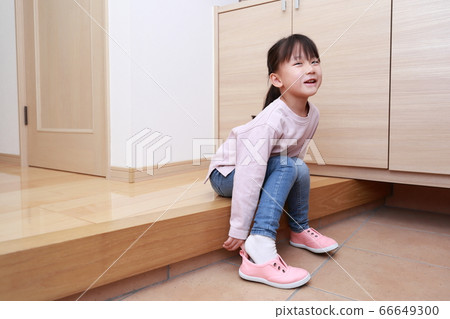 4-year-old girl wearing shoes at the entrance 66649300