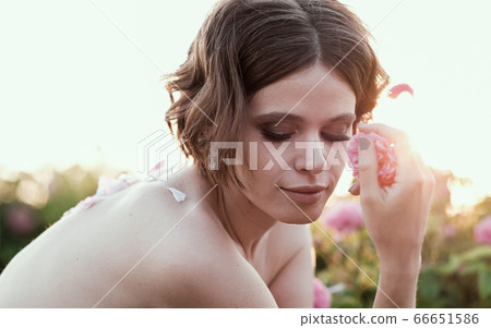 Beautiful young woman with curly hair posing near 66651586