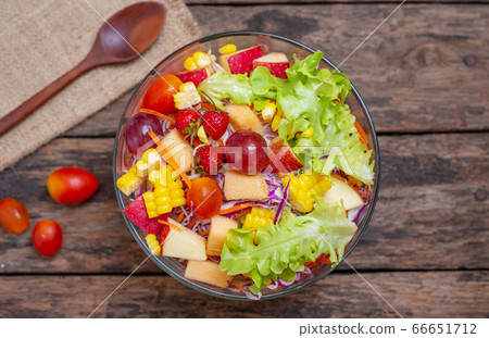 Fruits salad and vegetable in bowl on wooden table Fruits salad and vegetable in bowl on wooden table 66651712