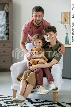 Young affectionate man hugging his adorable little son and pretty wife 66652531
