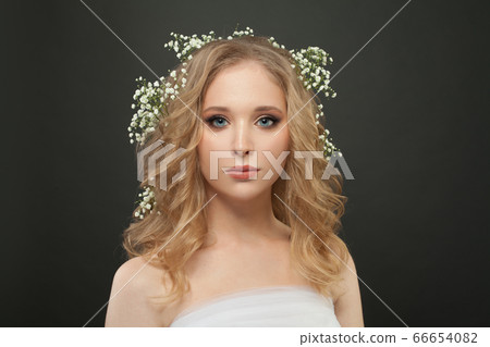 Blonde woman with white flowers on head on black 66654082
