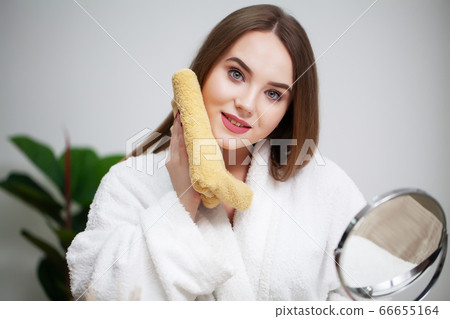 Cleansing facial skin, young woman holding yellow towel near facial skin after washing face Cleansing facial skin, young woman holding yellow towel near facial skin after washing face 66655164
