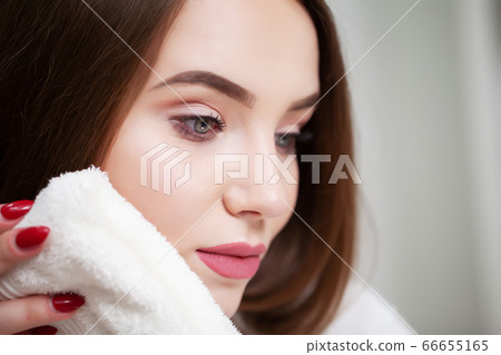 Cleansing facial skin, young woman holding white towel near facial skin after washing face Cleansing facial skin, young woman holding white towel near facial skin after washing face 66655165