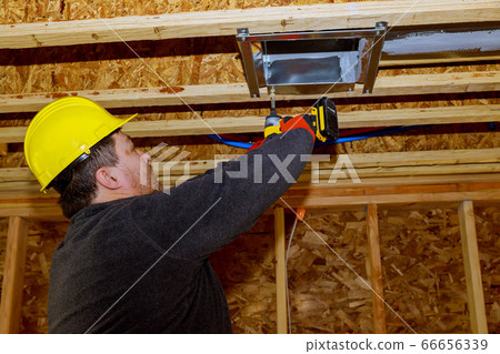 Worker installing air conditioner vents in new 66656339
