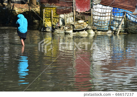Cox's Bazar in Bangladesh A Muslim woman walking on a flooded road Wearing an Islamic hijab Cox's Bazar in Bangladesh A Muslim woman walking on a flooded road Wearing an Islamic hijab 66657237