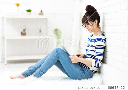 一個人獨自生活的女人正在觸摸一台筆記本電腦 66658422