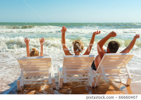 Happy family. Sits on the seashore and enjoys relaxing. Happy family. Sits on the seashore and enjoys relaxing. 66660407