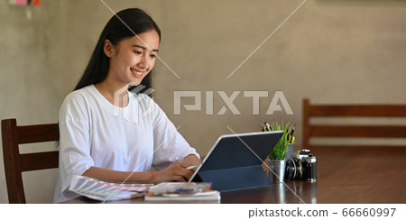 Photo of creative woman writing on computer tablet with keyboard case by stylus pen. Photo of creative woman writing on computer tablet with keyboard case by stylus pen. 66660997