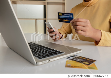 The hands of women holding credit cards and smartphones for online shopping and paying via the internet 66662763