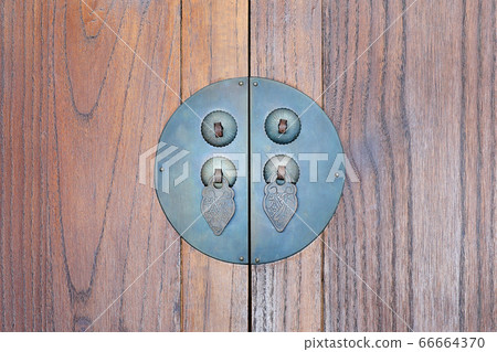 Ancient door handle on old wooden background Ancient door handle on old wooden background 66664370