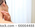 Woman with hands on her neck 66664488