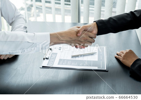 Office executives are interviewing job applicants in the meeting room and shackhands Office executives are interviewing job applicants in the meeting room and shackhands 66664530