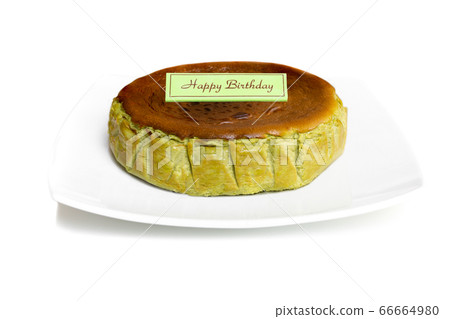 Mtacha Basque burnt cheese with birthday plate isolated in white background. Mtacha Basque burnt cheese with birthday plate isolated in white background. 66664980
