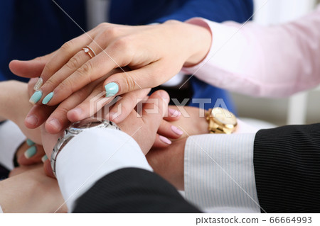Group of people in suits crossed hands in pile Group of people in suits crossed hands in pile 66664993