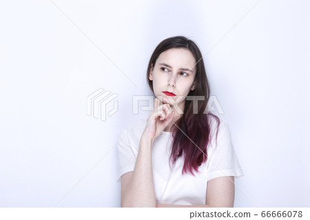 Young woman with red lipstick looks thoughtfully 66666078